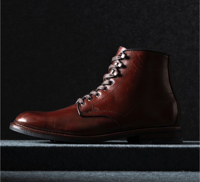 A side view of a burgundy leather derby boot with the toe facing left.  