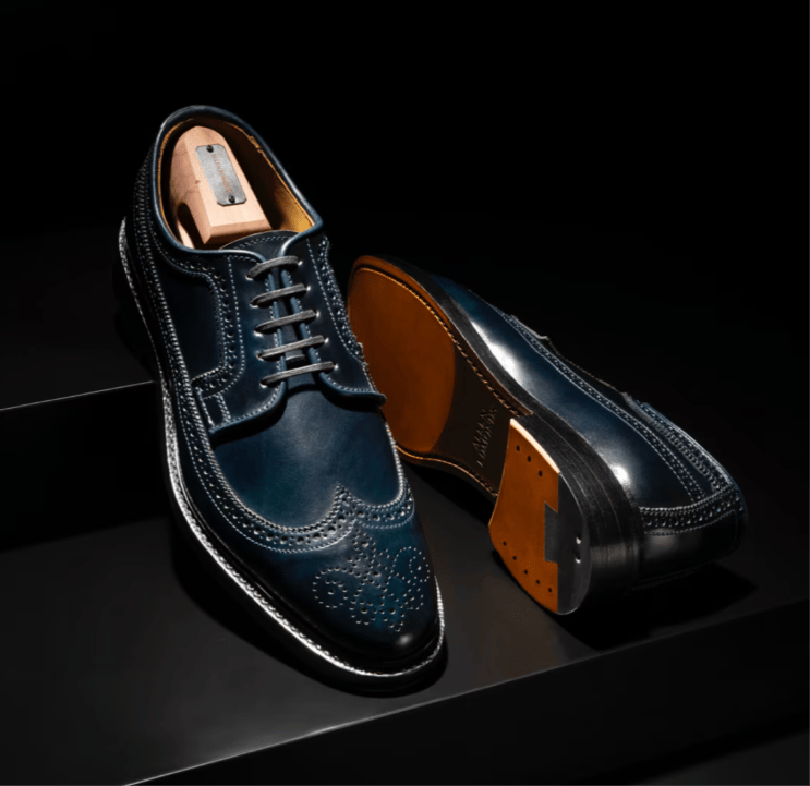 Navy leather Allen Edmonds Mason Wingtip Derby dress shoes displayed with a branded cedar shoe tree