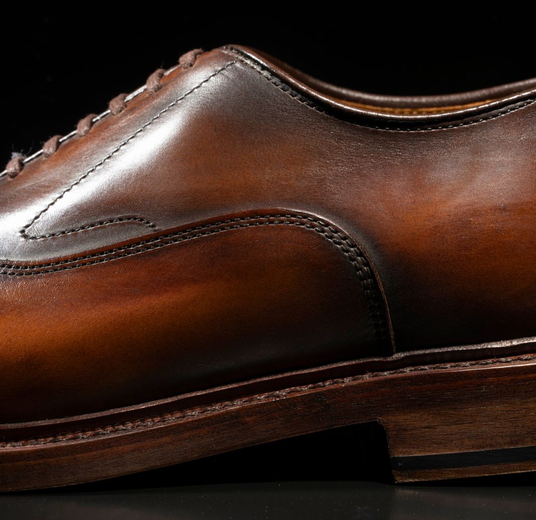 Close-up of the Allen Edmonds Manhattan Reserve coffee leather oxford, highlighting the detailed stitching and polished finish.